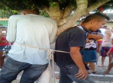 bandidos amarrados em arvore